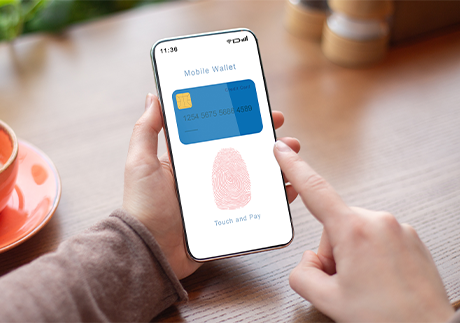 Display eines Smartphones mit Bankomatkarte und Finger-ID