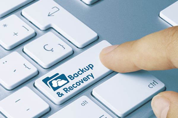 Finger auf Notebook-Taste mit der Aufschrift Backup & Recovery