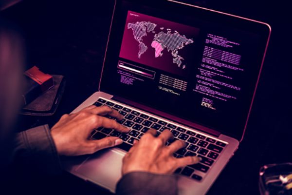 Offenes Notebook zeigt im Monitor Botnetz-Hacking 