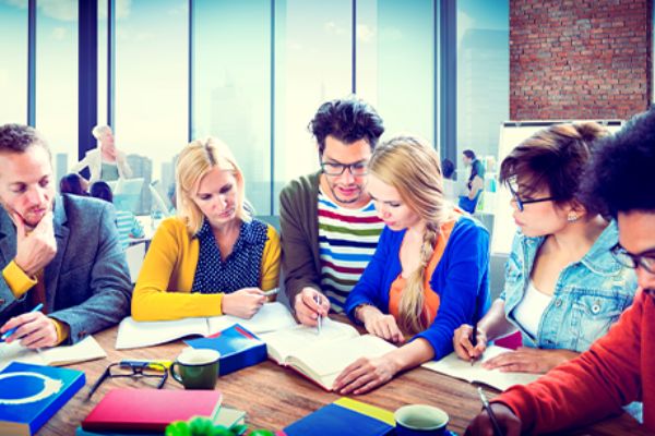 Studierende lernen gemeinsam und sitzen nebeneinander 
