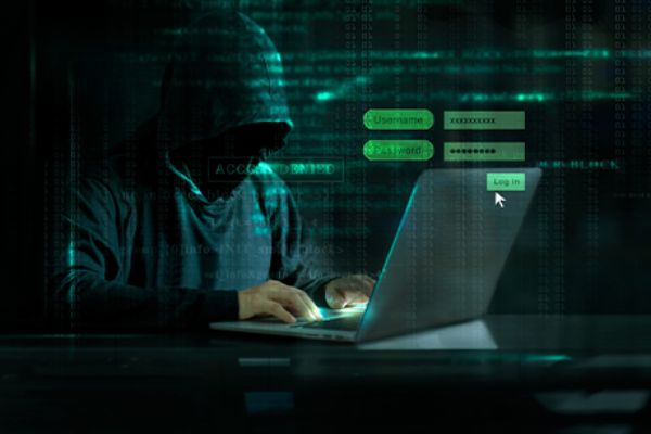 KI-Angriffe: Hacker mit Kapuze vor einem Laptop 
