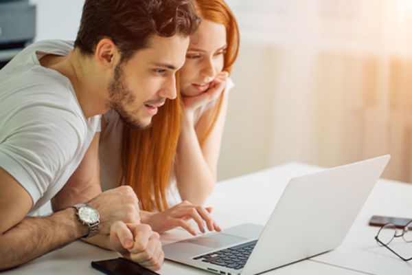 Mann und Frau sitzen vor einem Laptop 