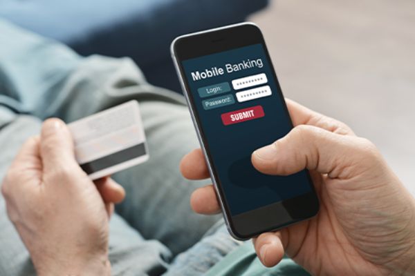 Hände halten Smartphone und Bankkarte in Nahansicht