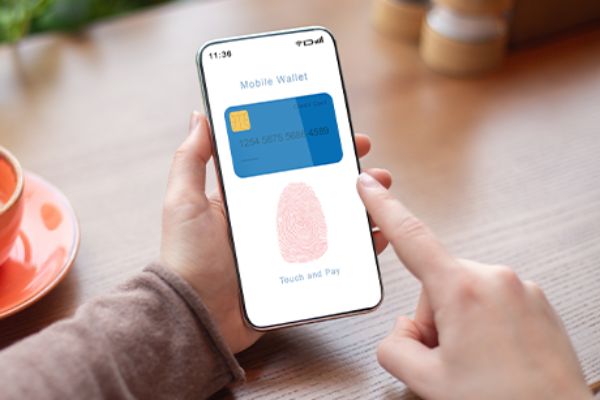 Display eines Smartphones mit Bankomatkarte und Finger-ID