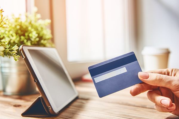 Frau sitzt am Computer und shoppt online