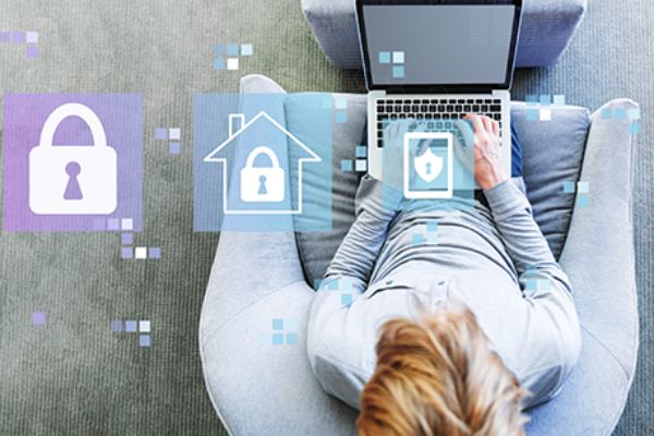 Person sitzt auf einem Sessel und arbeitet an einem aufgeklappten Laptop
