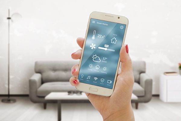 Frau hält Smartphone mit Smart Home Steuerung
