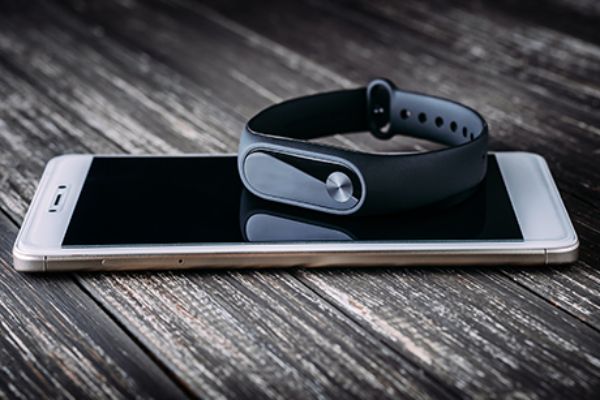 Ein smartes Armband liegt auf einem Smartphone