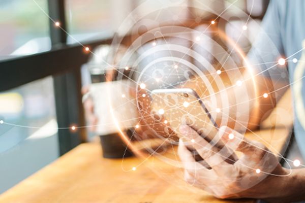 Smartphone mit Social-Media-Symbolen in der linken Hand