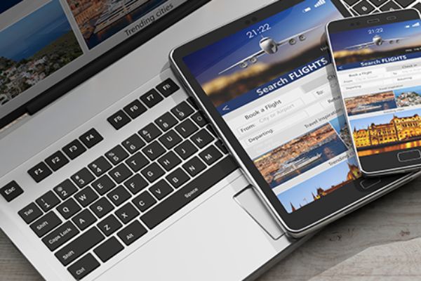 Buchungsplattform für Flüge ist auf Laptop, Handy und Tablet geöffnet