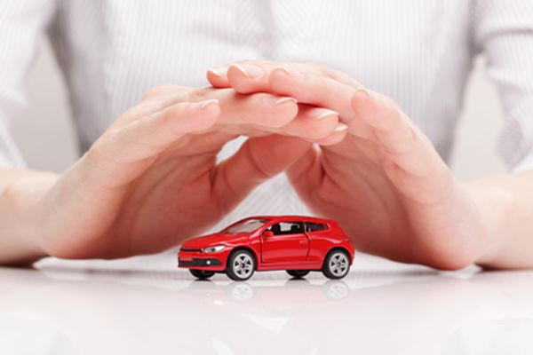Hände schützend über Spielzeugauto gehalten (Symbolbild für eCall) 