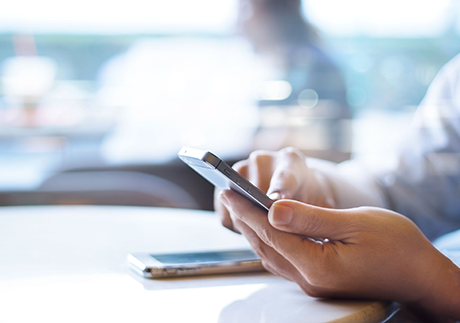 Frau bedient Smartphone mit dem Finger