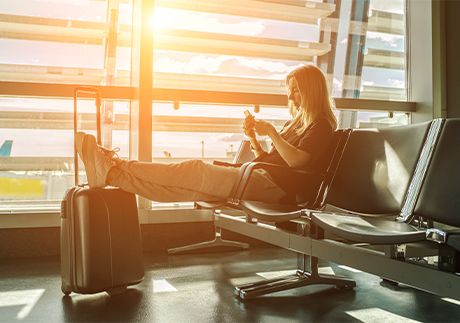 Frau mit Koffer wartet am Flughafen 