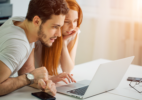 Mann und Frau sitzen vor einem Laptop