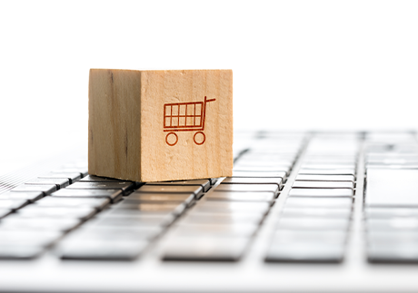 Holzwürfel mit Abbildung eines Einkaufswagens auf einer Tastatur