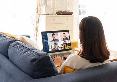 Junge Frau mit Laptop auf einem Sofa