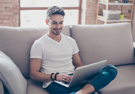 Mesh-WLAN: Mann mit Laptop sitz auf einem Sofa. 