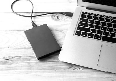 Offener Laptop mit angeschlossenem USB-Speichermedium.