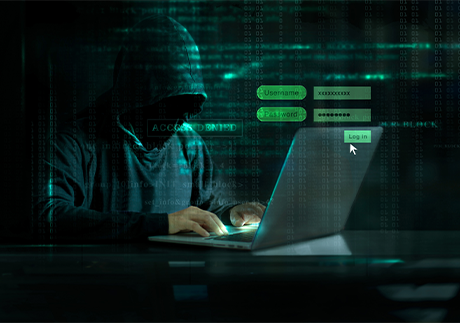 KI-Angriffe: Hacker mit Kapuze vor einem Laptop