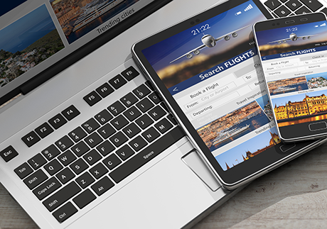 Buchungsplattform für Flüge ist auf Laptop, Handy und Tablet geöffnet