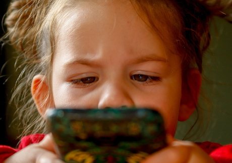 Junges Mädchen schaut auf ein Smartphone