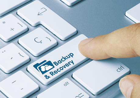 Finger auf Laptop-Taste mit Aufschrift Backup & Recovery